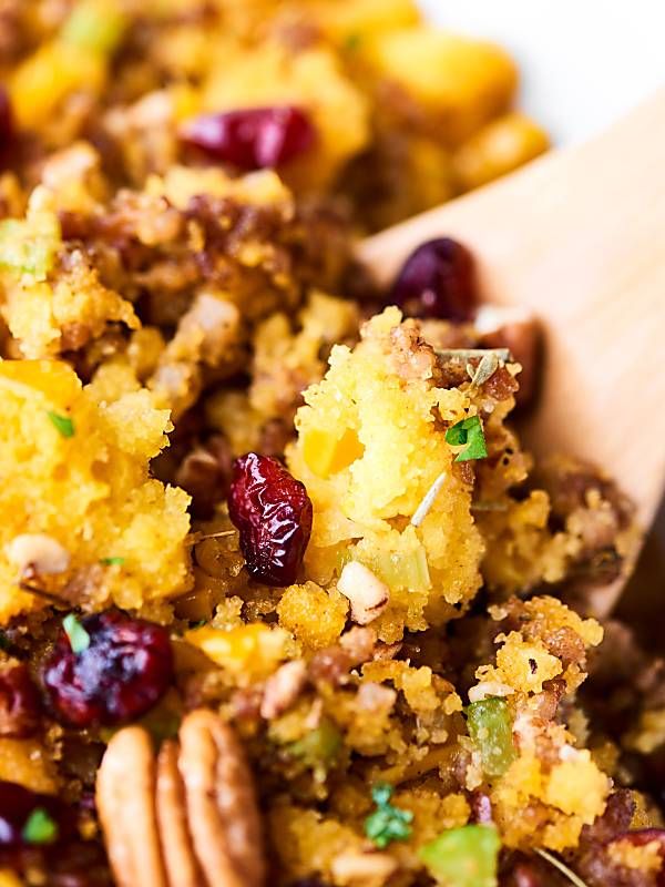 a wooden spoon filled with stuffing and cranberries