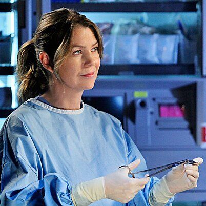 a woman in scrubs is holding scissors