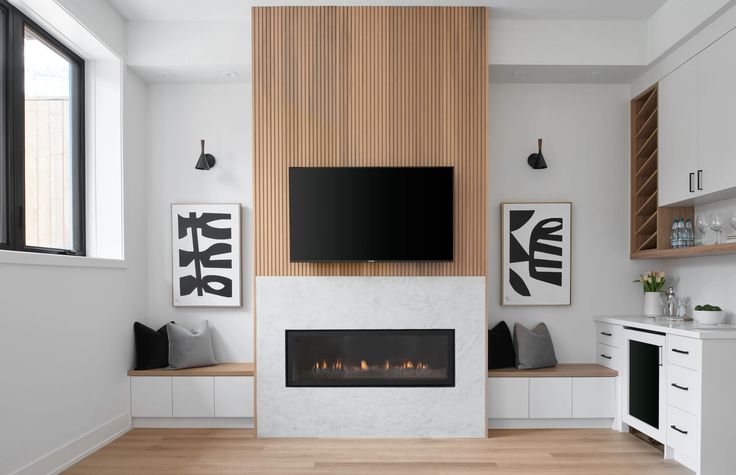 a living room with white furniture and a flat screen tv mounted on the wall above a fireplace