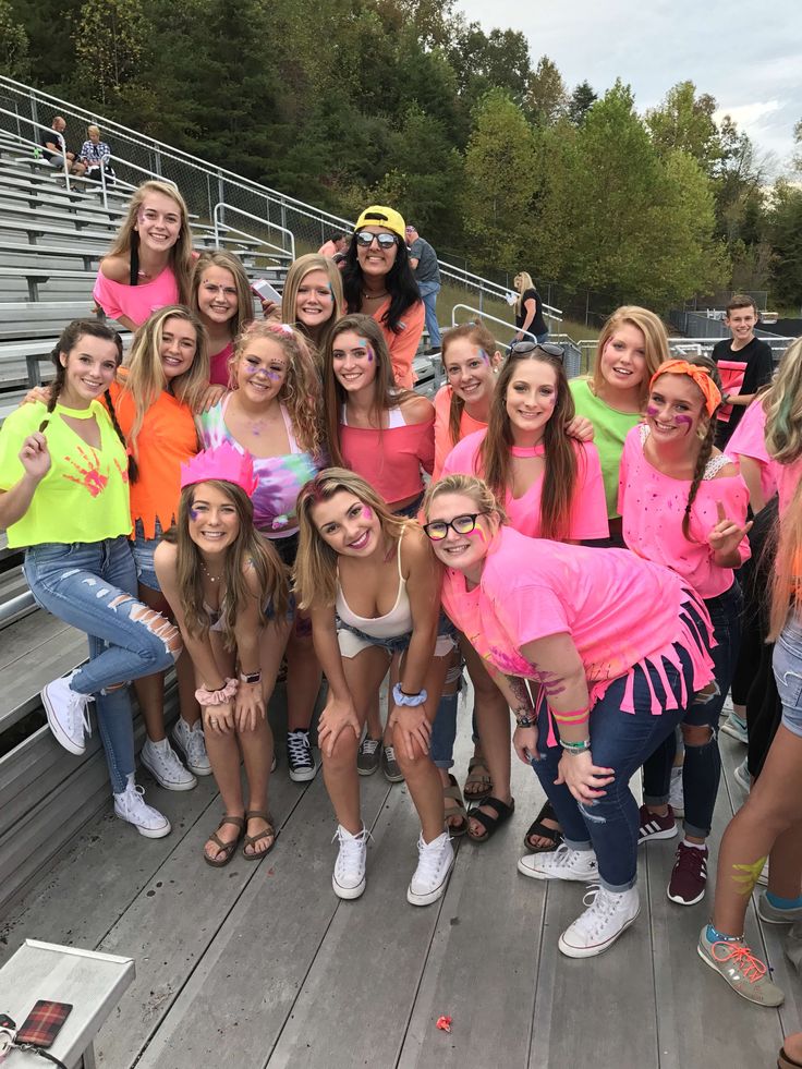 a group of young women standing next to each other in front of bleachers