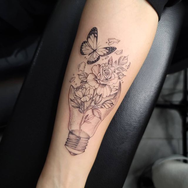 a woman's arm with flowers and a butterfly on it