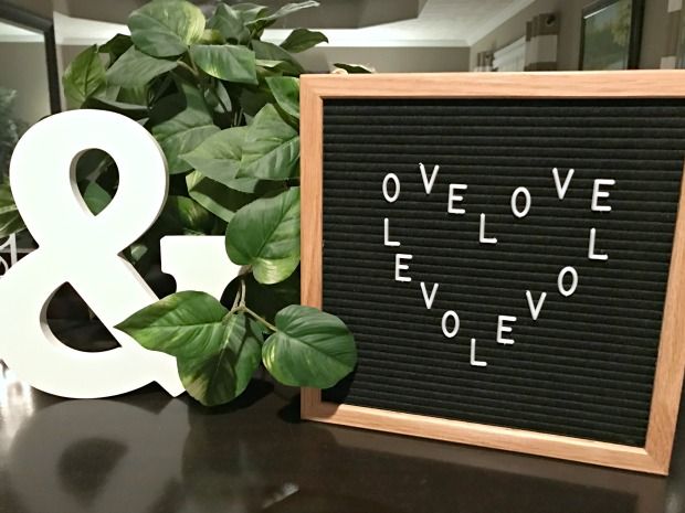 a black and white sign sitting on top of a table next to a green plant