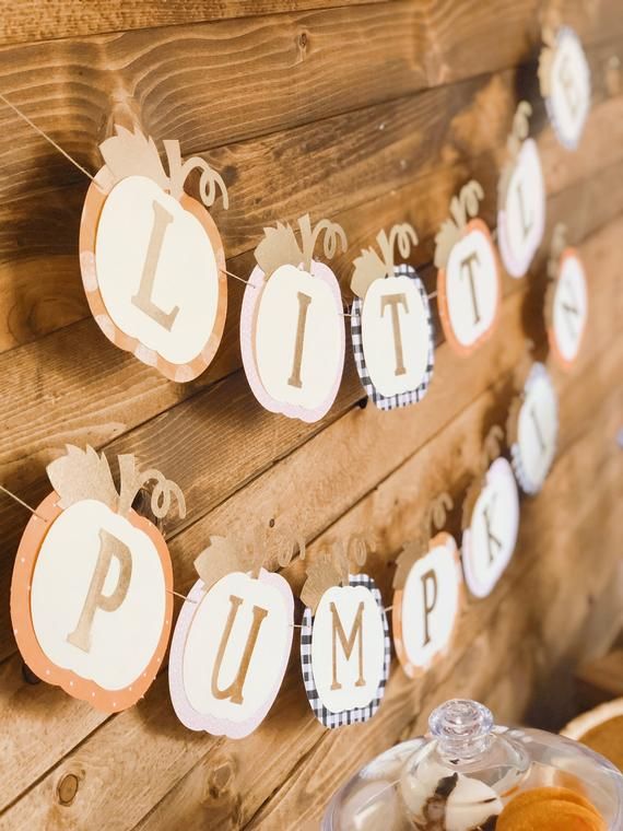 there are some pumpkins hanging on the wall with little pumpkins attached to it