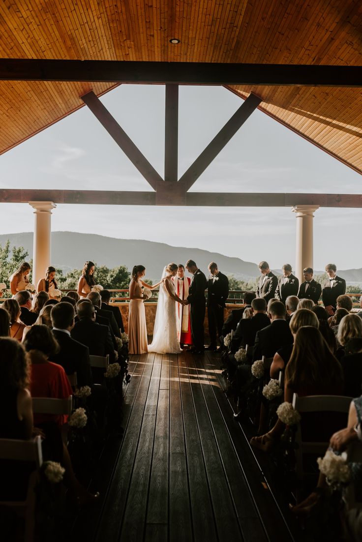 a bride and groom standing at the end of their wedding ceremony in front of an audience