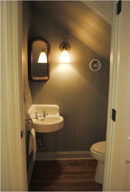 a bathroom with a sink, mirror and light on the side of the door way