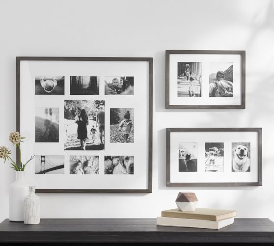 a black and white photo hangs on the wall next to two vases with flowers