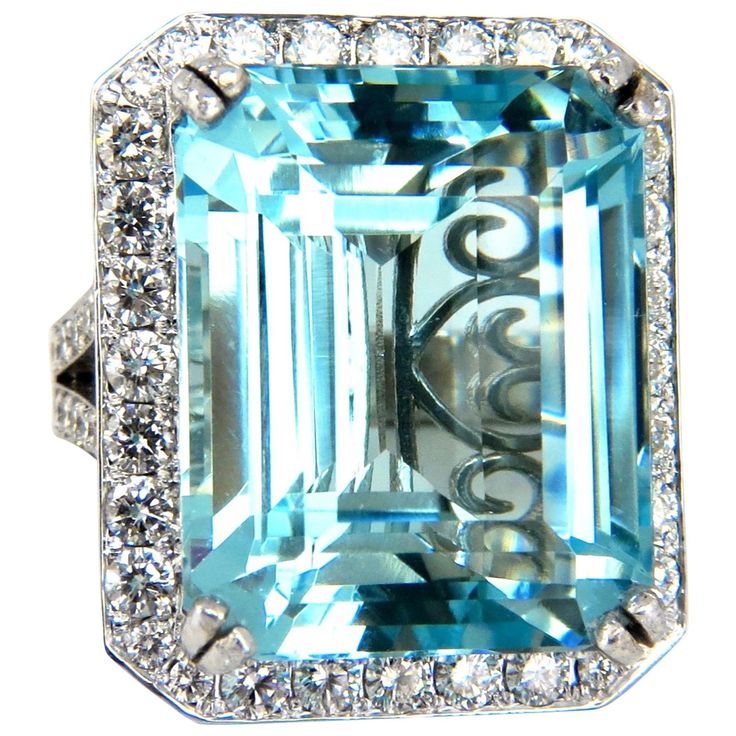 an aqua blue and white topazte ring with diamonds on the sides, set in 18k white gold