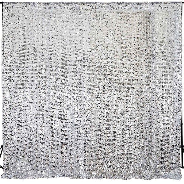 a white curtain with silver sequins hanging from it's side in front of a wooden floor