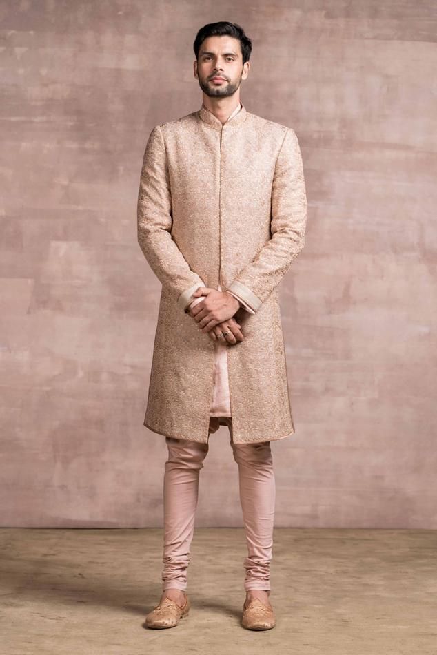 Salmon sherwani featuring chikankari work, with printed textured base and Kasab embroidery. Paired with silk kurta and churidar.
Component: 3
Pattern: Embroidered
Type Of Work: Chikankari and Kasab
Neckline: Mandarin
Sleeve Type: Straight Full Sleeves
Fabric: Sherwani and Kurta: Georgette; Churidar: Poplin Lycra
Color: Pink
Other Details: 
Front and side slit sherwani
Floral motif embroidered work
Occasion: Groom, Wedding - Aza Fashions Pink Sherwani, Sherwani For Men Wedding, Embroidered Sherwani, Groom Dress Men, Mens Sherwani, Sherwani For Men, Tarun Tahiliani, Indian Fashion Designers, Salmon Pink