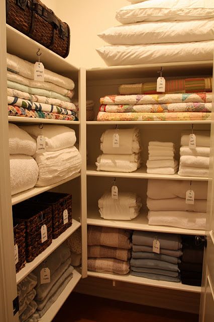 the closet is full of folded towels and folded linens, all neatly stacked on shelves