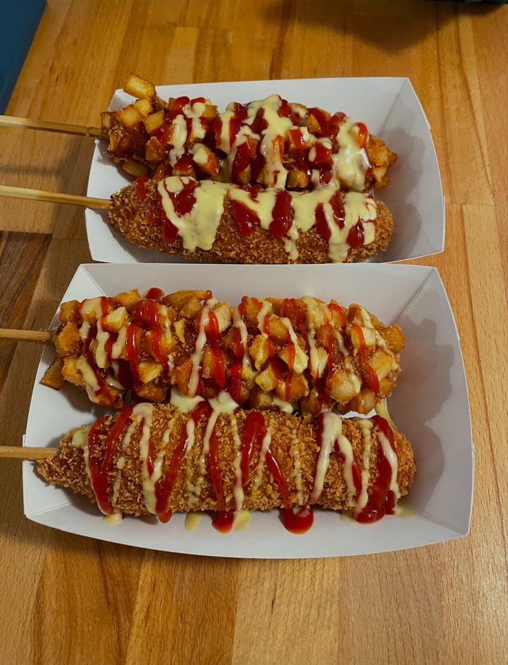 two hot dogs covered in ketchup and relish sitting on top of white plates