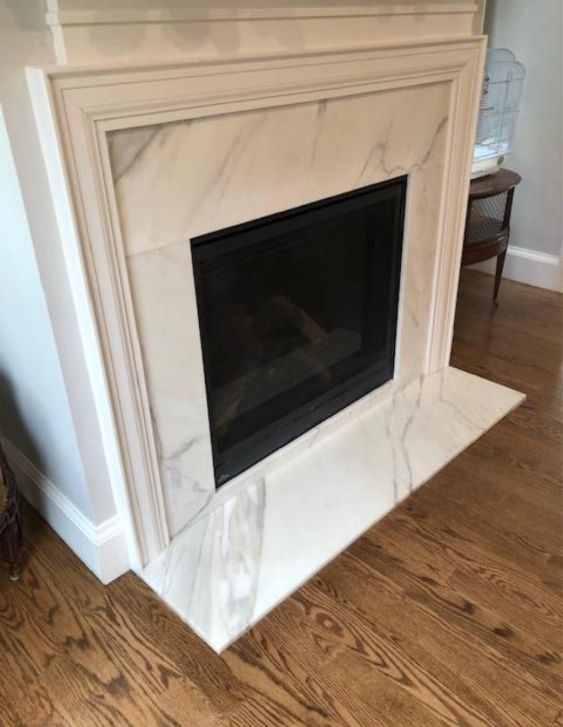 a white marble fireplace surround in a living room