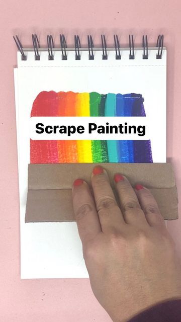 a hand holding a piece of paper with the word scrape painting on it in front of a pink background