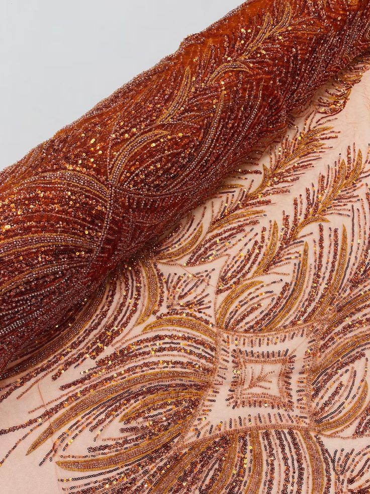 an embroidered fabric with gold sequins and beads on the bottom half of it