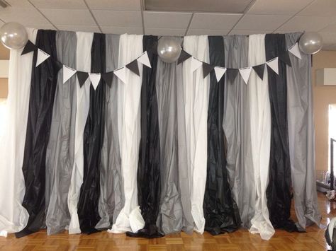 black and white striped curtains with balloons hanging from the ceiling in front of them on a wooden floor