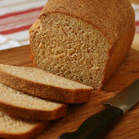 a loaf of bread sitting on top of a wooden cutting board next to a knife