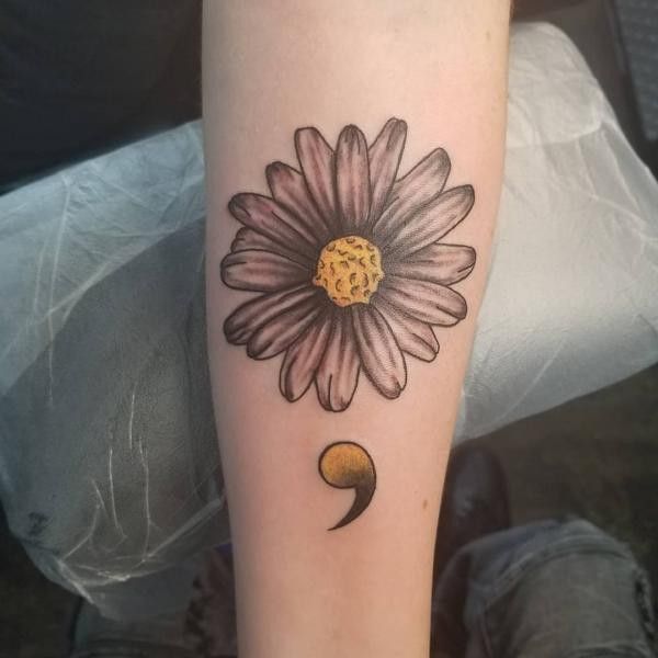 a woman's leg with a flower tattoo on the side of her leg and a crescent