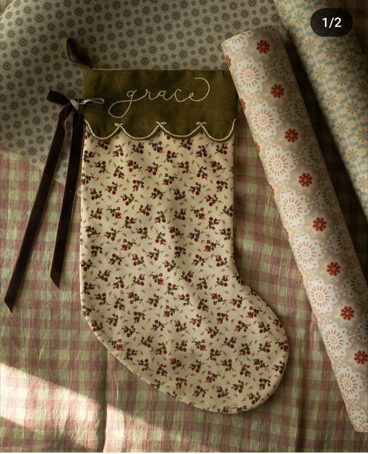 a christmas stocking with the word grace written on it next to a roll of fabric