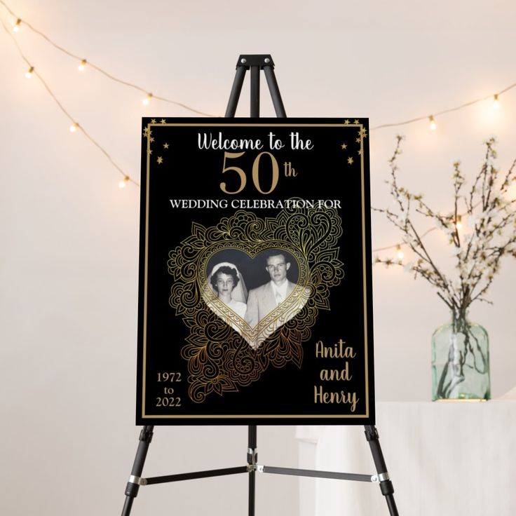 a black and gold 50th anniversary sign with an image of two people in the heart