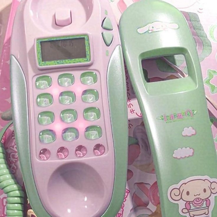 two cell phones sitting next to each other on top of pink and green paper towels