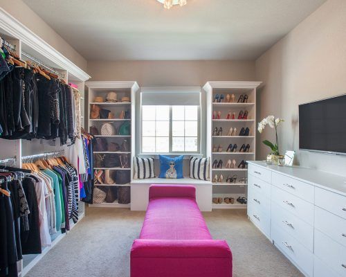 a walk in closet filled with lots of clothes