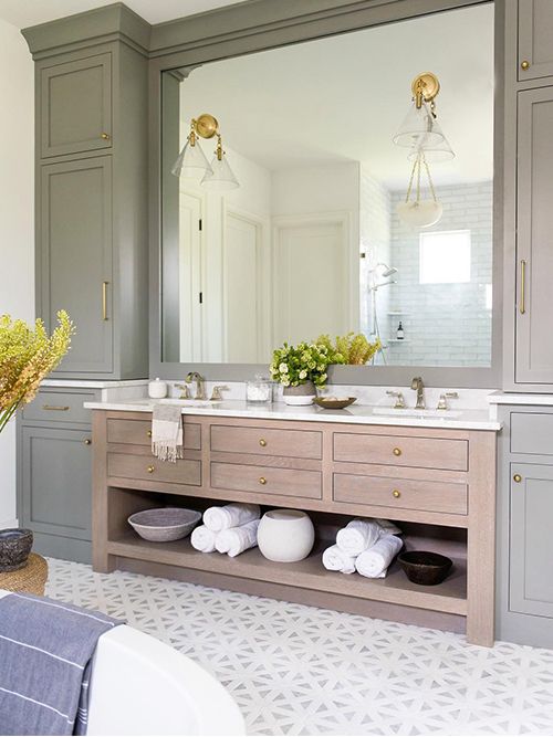 a bathroom with gray cabinets and white counter tops is pictured in this image, there are yellow flowers on the sink