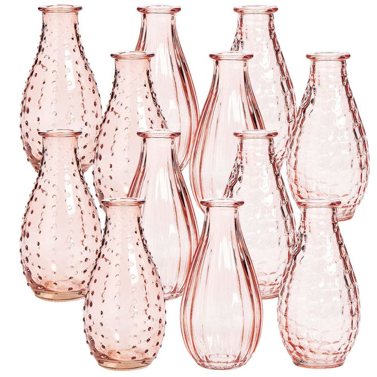 a group of pink vases sitting next to each other on a white table top