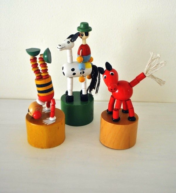 three wooden toy figurines sitting on top of each other