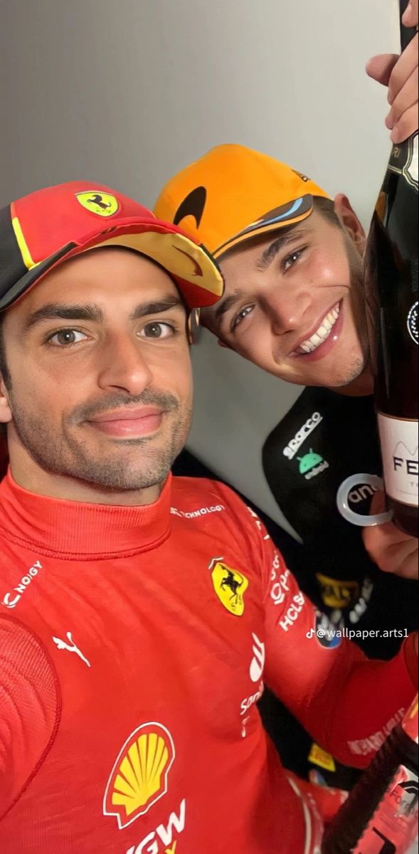 two people are posing for a photo while holding up wine bottles and smiling at the camera