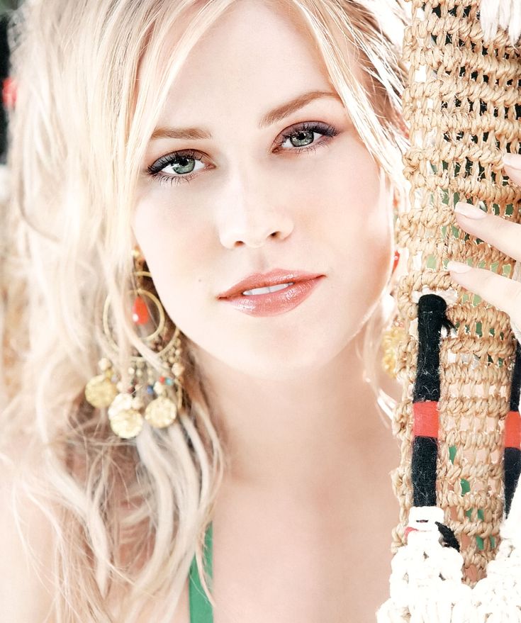 a woman with blonde hair and earrings posing for a magazine cover photo wearing an elaborate headdress