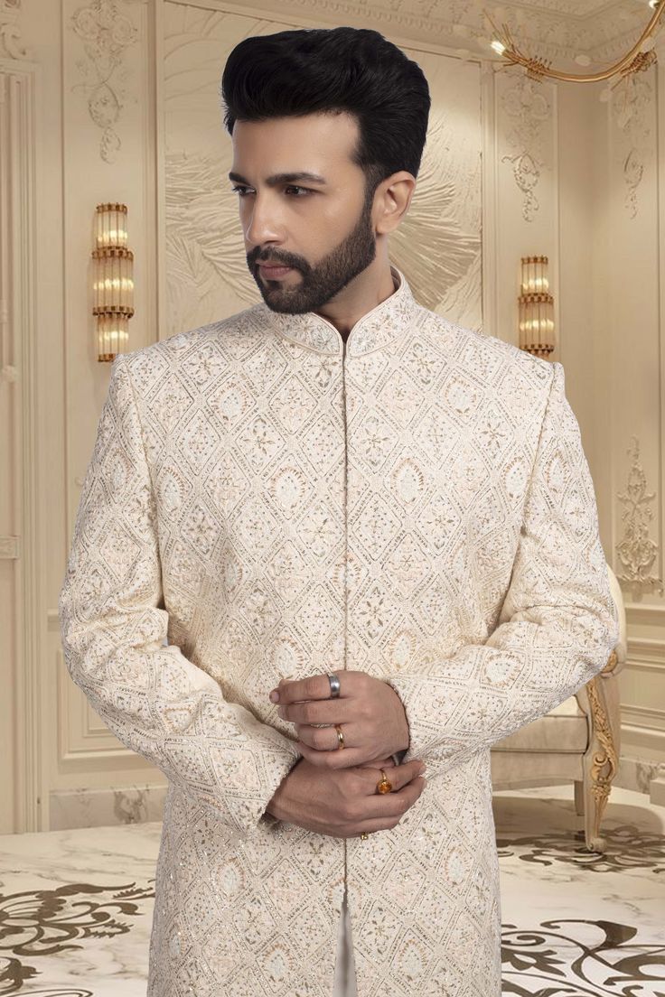 Introducing our Mens Sherwani R14-S66, a luxurious and sophisticated choice for grooms. Adorned with intricate zardozi embroidery, this sherwani exudes elegance and exclusivity. Make a statement on your special day with this magnificent piece. Off White Sherwani With Intricate Embroidery For Wedding, Elegant Cream Bandhgala With Chikankari Embroidery, Formal Off White Nehru Jacket With Dabka, Groom's Eid Sherwani With Chikankari Embroidery, Elegant Bandhgala With Chikankari Embroidery For Groom, Cream Nehru Jacket With Naqshi For Reception, Elegant Embroidered Sherwani For Groom, Cream Bandhgala With Zari Work For Reception, Cream Traditional Wear With Resham Embroidery For Groom