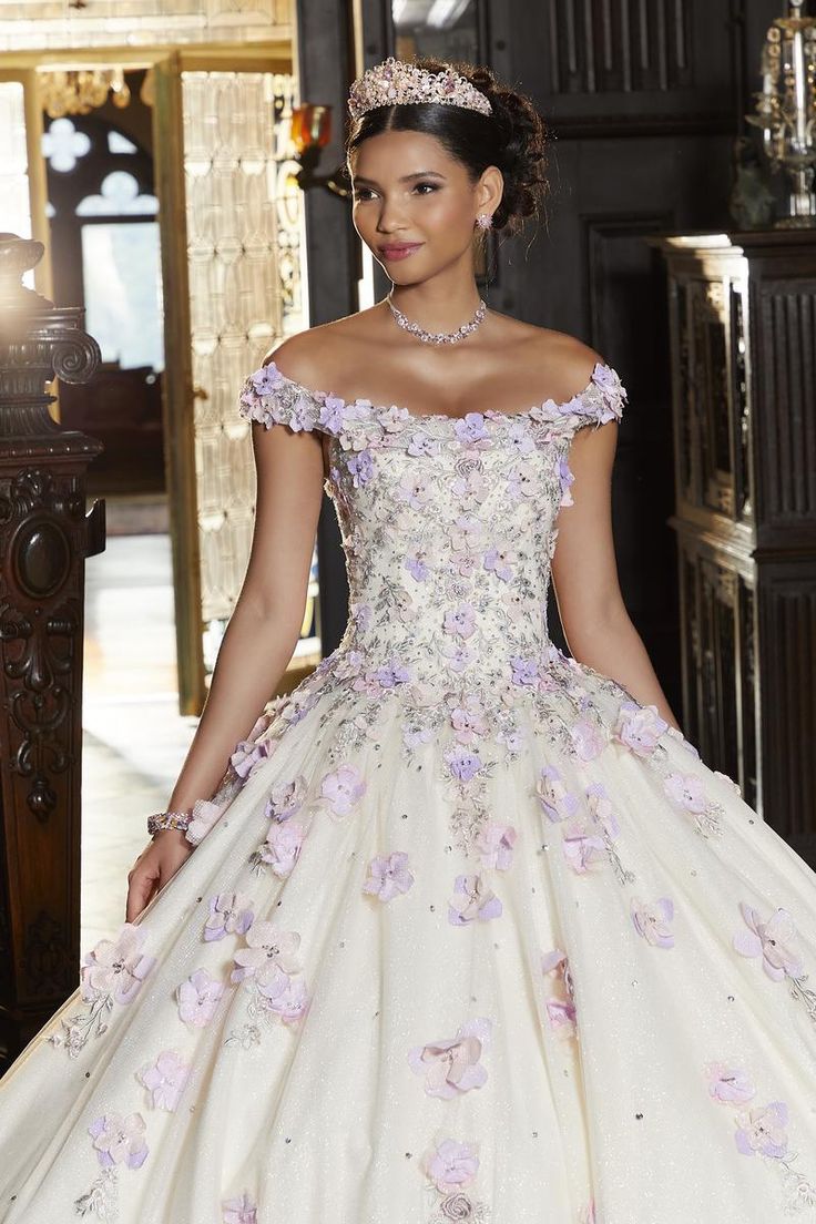 Feel like a fairytale princess in this gorgeous ballgown from Vizcaya by Morilee. The gown showcases a delicate off-the-shoulder bodice decorated with multi-colored 3D crystal beaded flowers on a crystallized tulle skirt. Make this your go-to gown for your special day! Floral Quince Dress, Vestido Charro, Pansy Garden, Sangria Dress, Tulle Balls, Quince Dress, Princess Sleeves, Mori Lee, Ball Gown Skirt