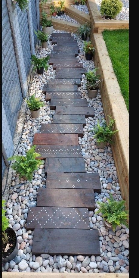 a wooden walkway surrounded by rocks and plants