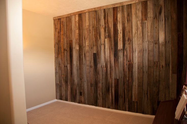 an empty room with wood paneling on the wall