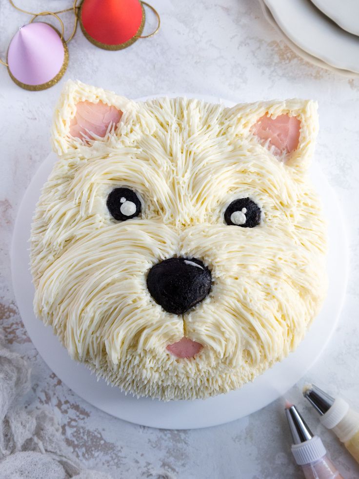 there is a cake that looks like a dog's face on the plate next to it