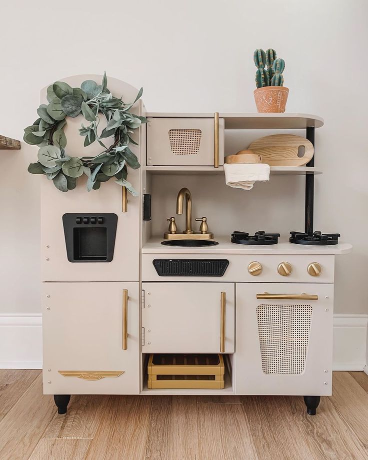 an old fashioned wooden play kitchen with potted plants