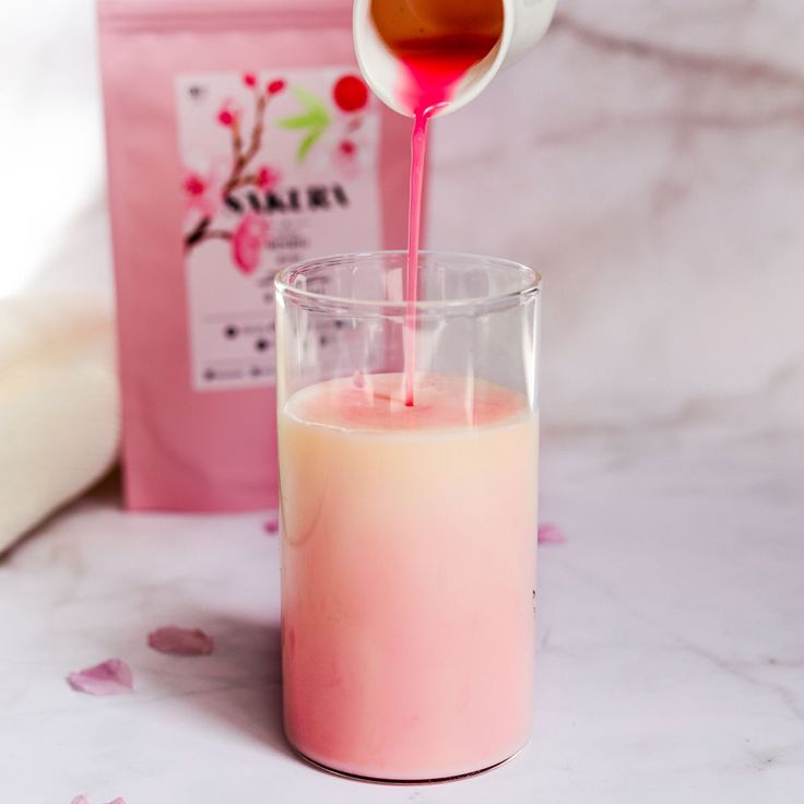 a pink liquid being poured into a glass