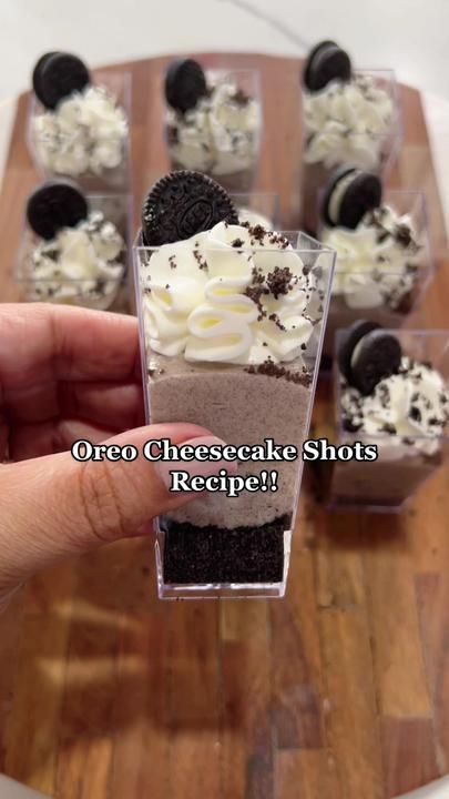 someone holding up a cupcake with oreo cheesecake shots in it