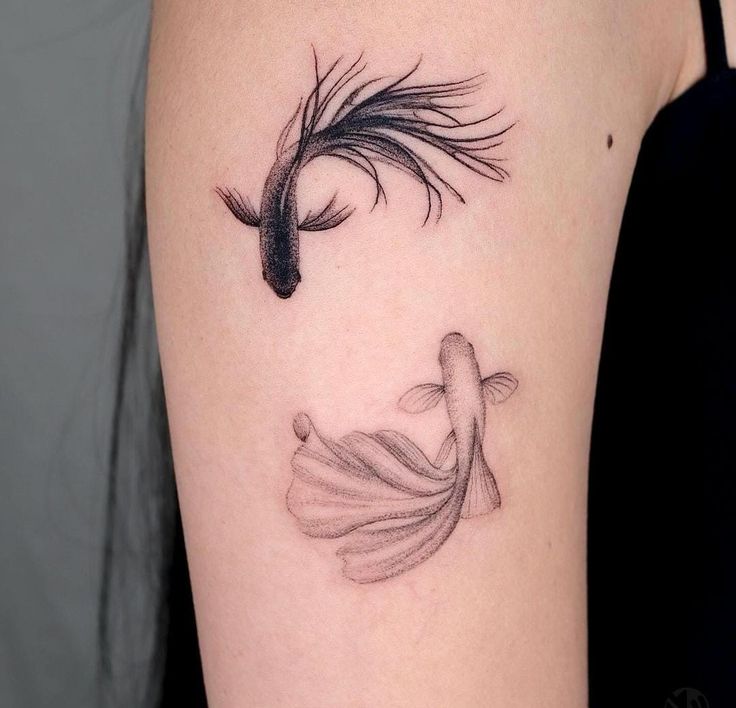 a woman's arm with a fish tattoo on the left side of her body