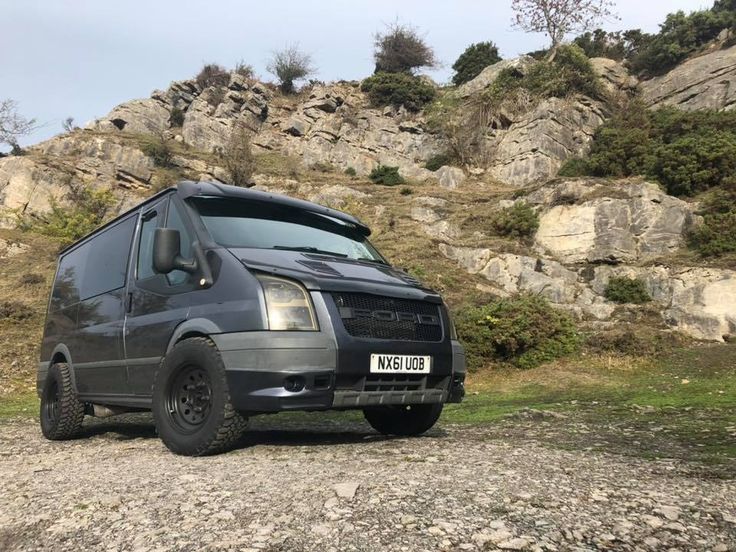 a van parked on the side of a rocky road