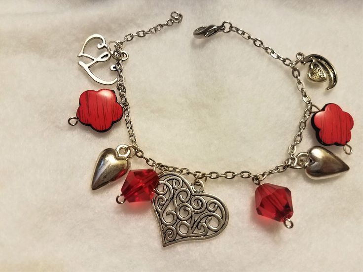 **PERCECT FOR VALENTINE GIFTING** This silver chained charm bracelet contains charms of silver with red companion beads closing with a lobster clasp. This piece is a finished length of approximately 8 inches long Red Dangle Charms With Lobster Clasp, Red Dangle Charm Bracelet As Gift, Red Dangle Charm Bracelet For Gift, Red Heart-shaped Metal Bracelets, Red Heart-shaped Charm Bracelet, Red Heart-shaped Metal Bracelet, Red Charm Bracelet With Heart Charm As Gift, Red Metal Bracelets With Charms, Elegant Red Charm Bracelet With Heart Charm