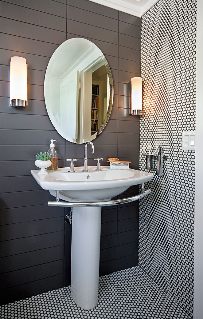 a white sink sitting under a bathroom mirror next to a wall mounted faucet