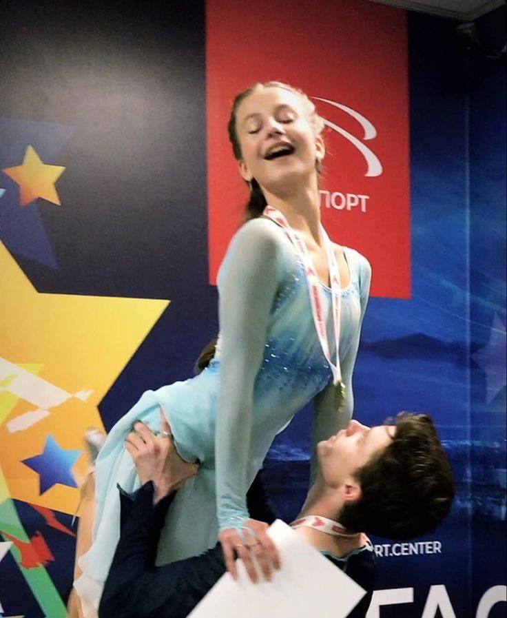 a woman is being lifted by a man in front of a wall with colorful stars