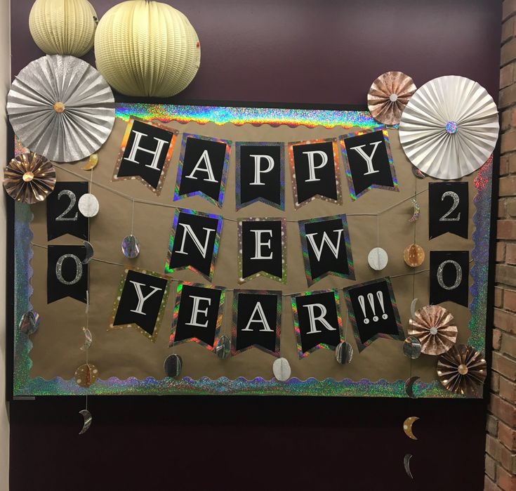 a happy new year banner hanging on the wall next to some paper fans and decorations