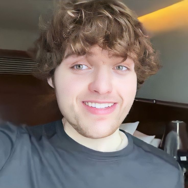 a close up of a person wearing a t - shirt and smiling at the camera