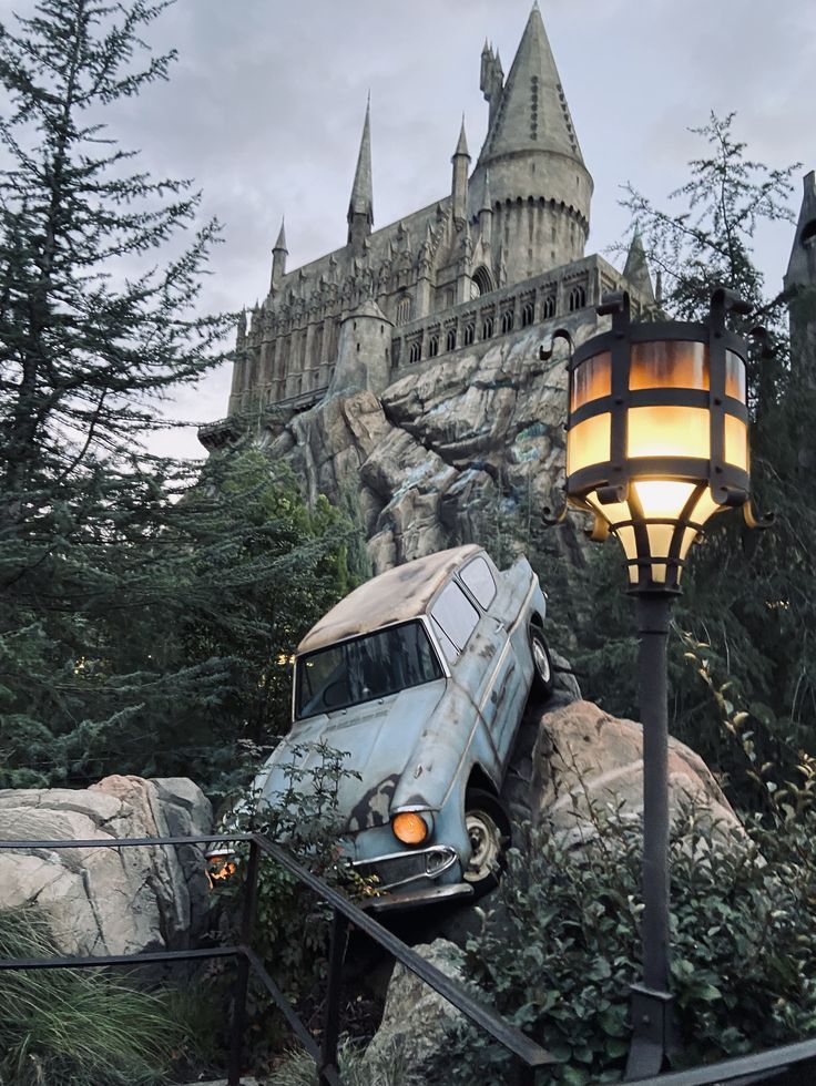 an old van is parked in front of a castle