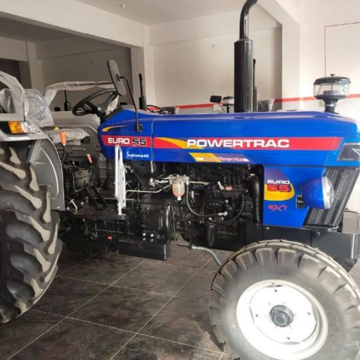 a blue tractor parked in a garage