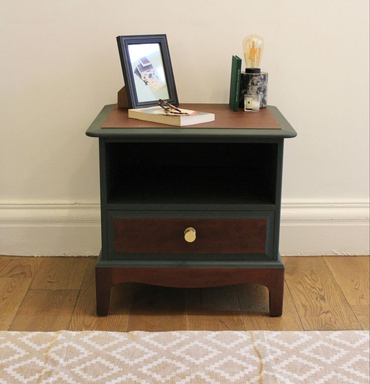 a small wooden table with two drawers and a photo frame on it's top