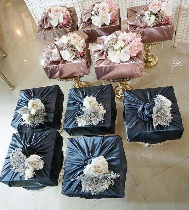 six gift boxes with flowers on them sitting on the floor next to each other, all wrapped in satin material