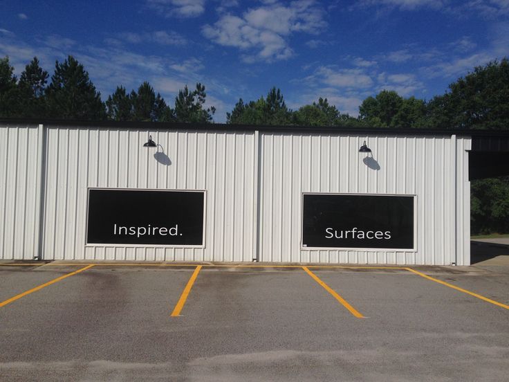 two black and white signs on the side of a building that says, inspired surfaces